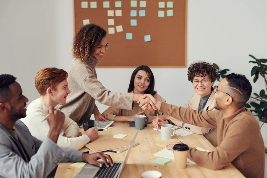 People_around_table_shaking_hands