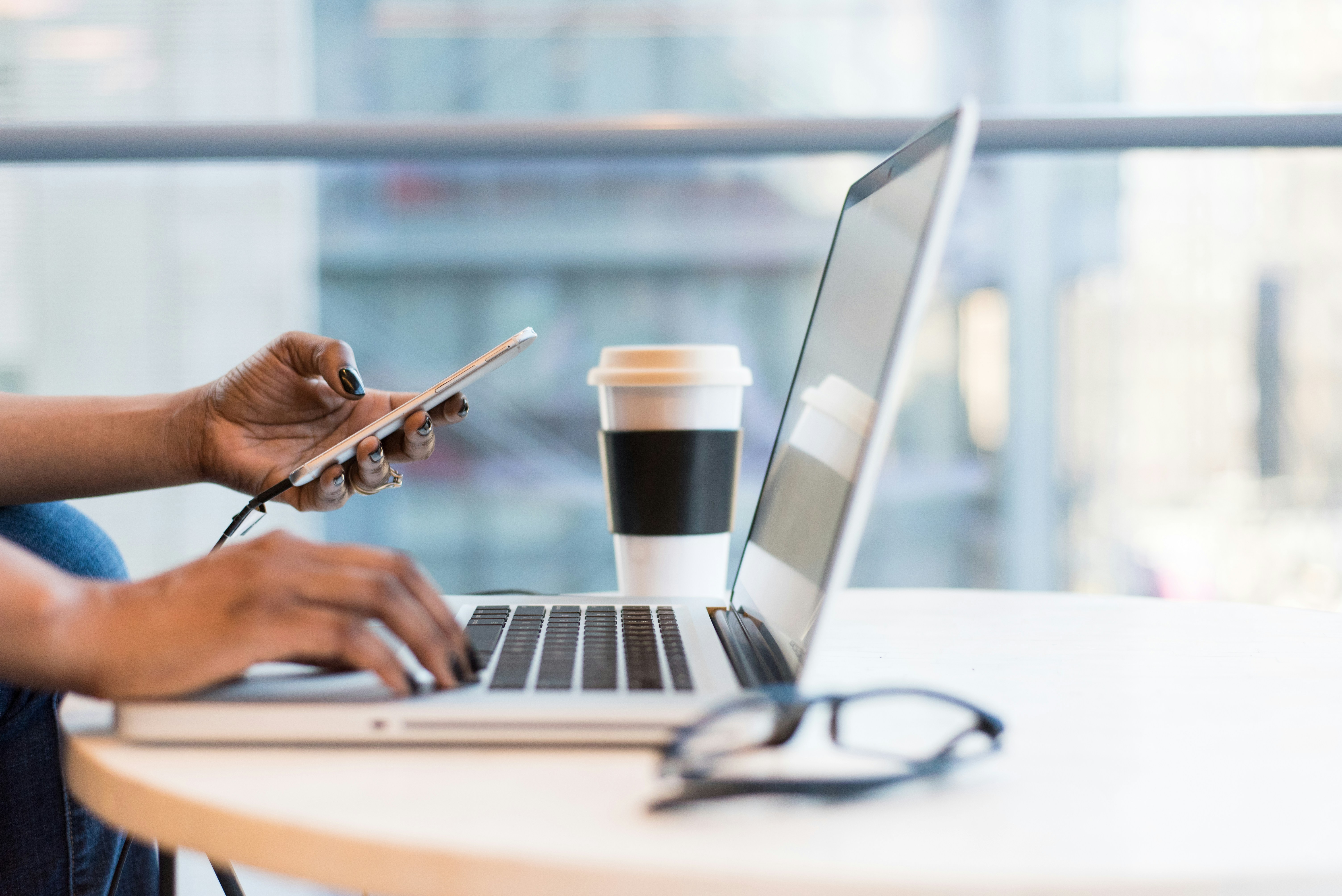 person-using-smartphone-and-macbook