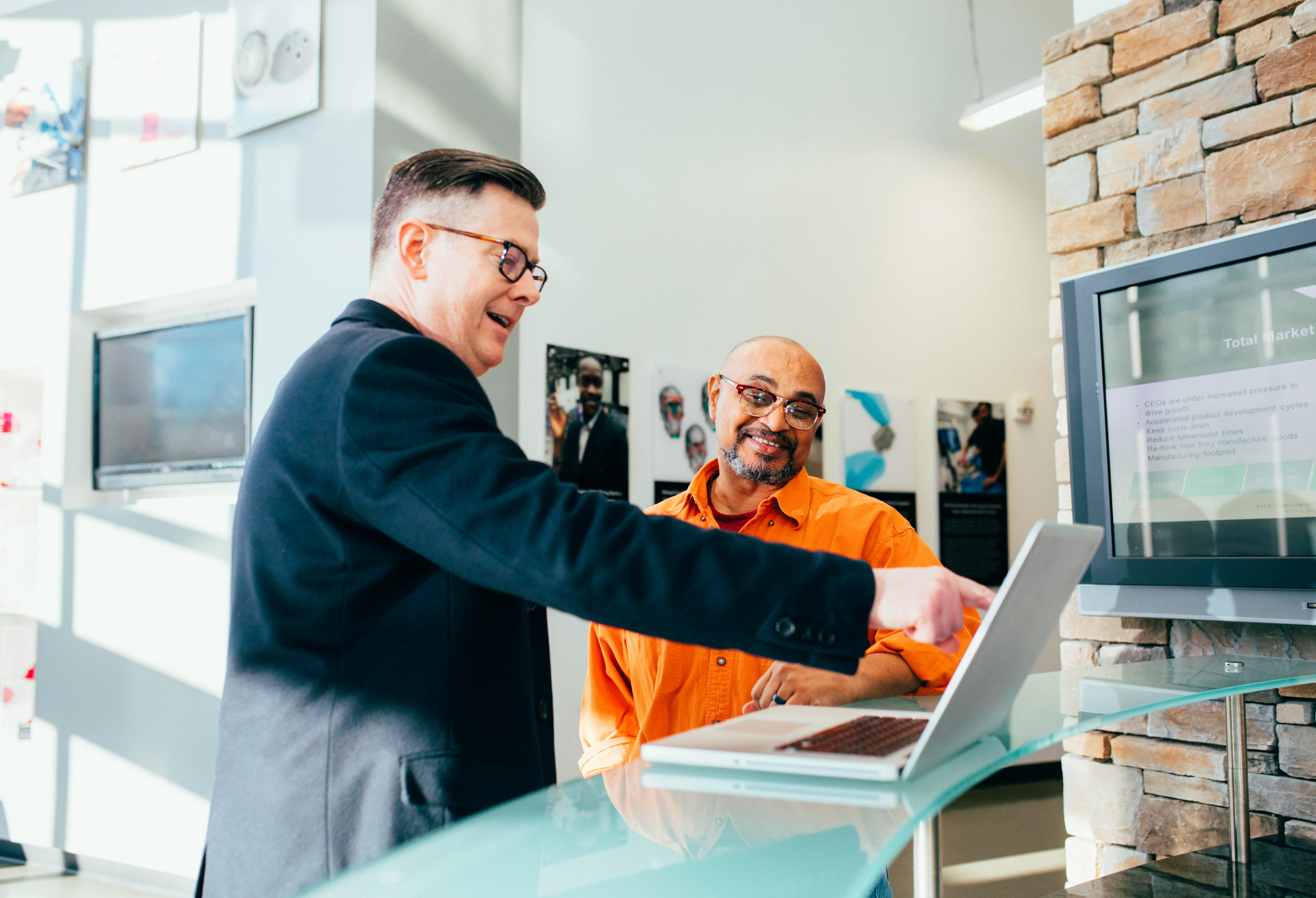 man-pointing-to-a-laptop-as-another-man-looks-on