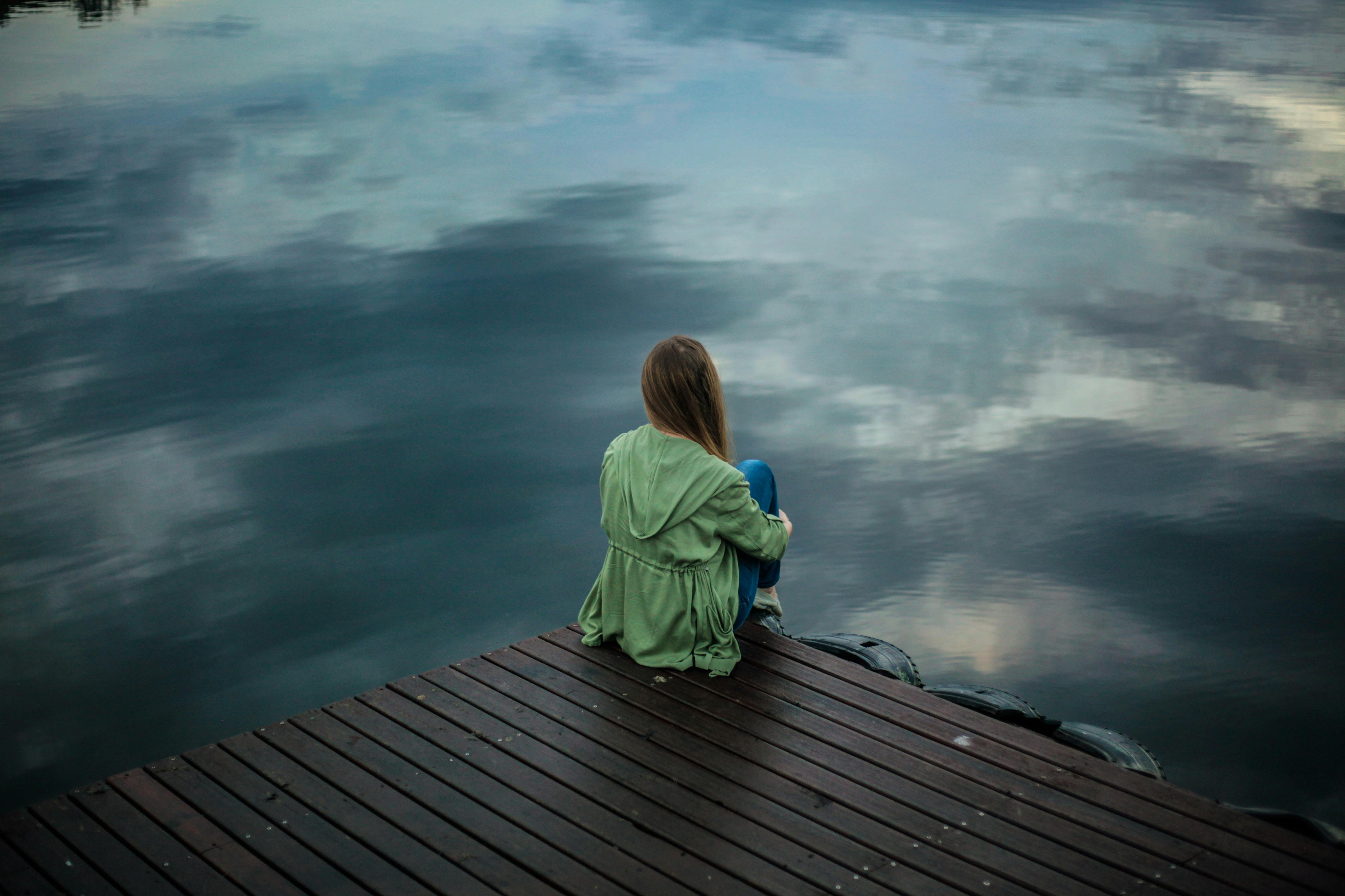 woman sitting alone on plank