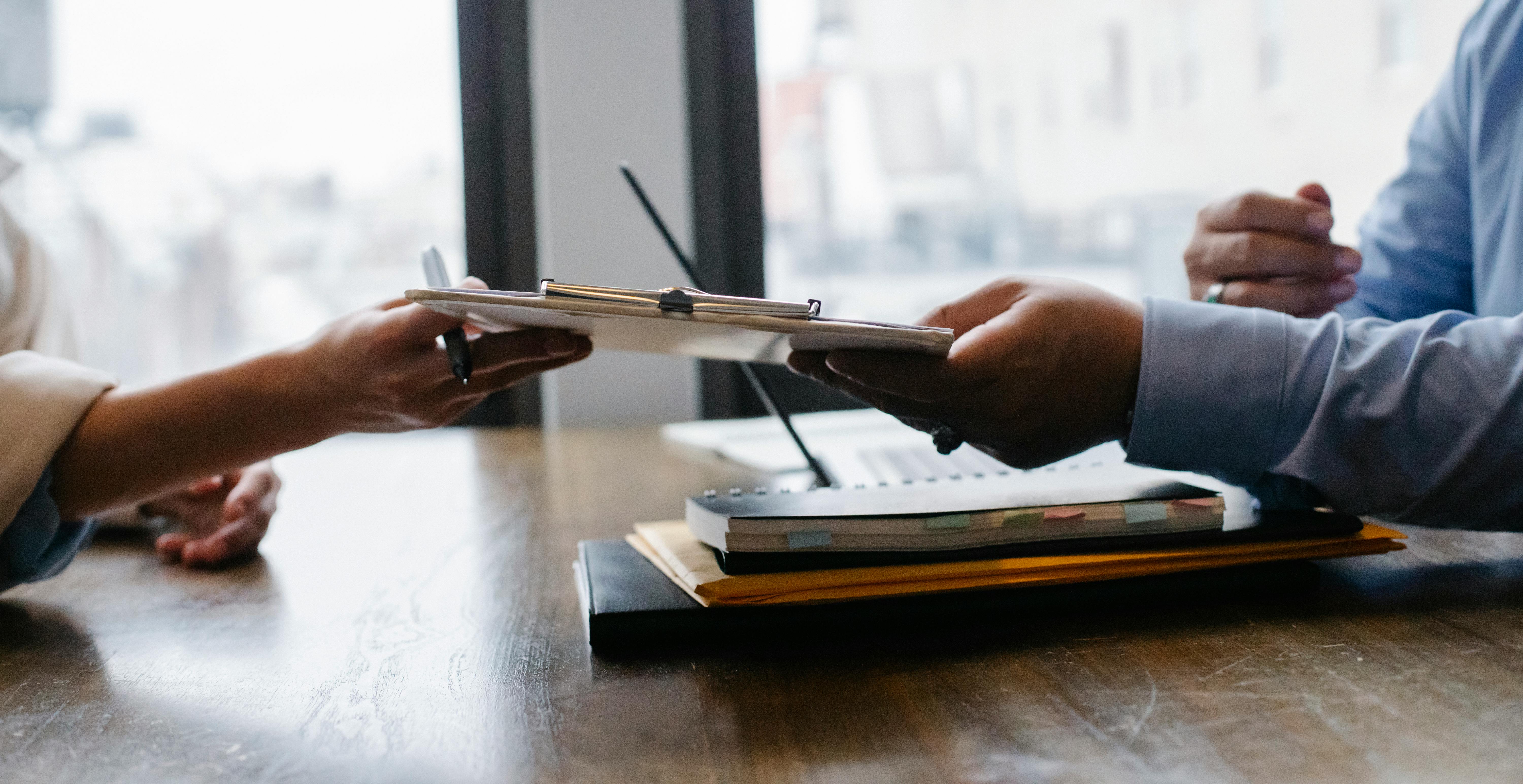 image of two people handing off clipboard