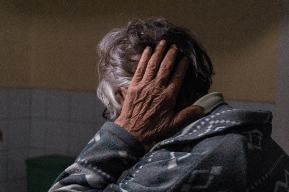 an-older-woman-covering-her-ears-with-her-hands