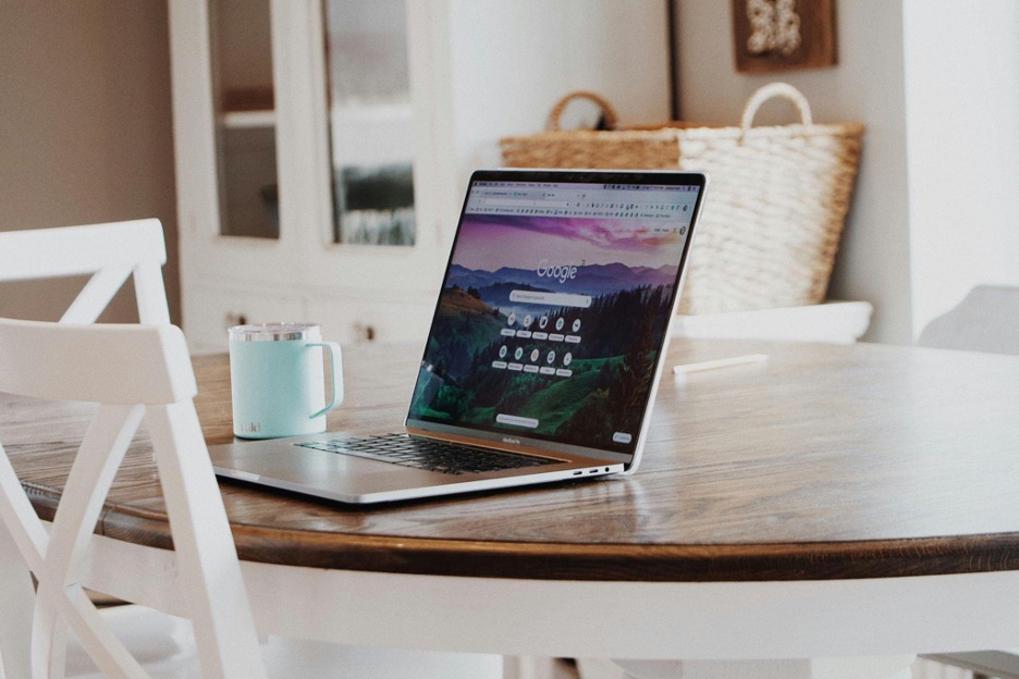 laptop-and-coffee-mug-sitting-on-a-round-wooden-table