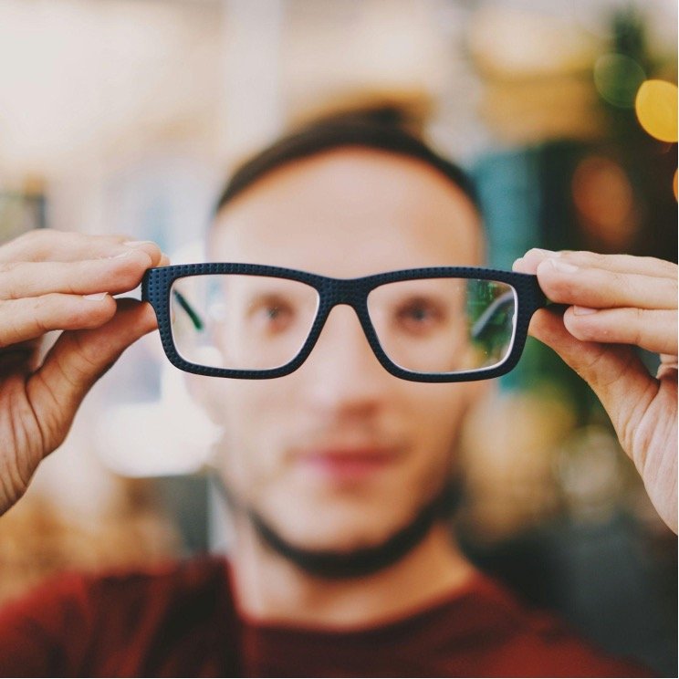 person-holding-eyeglasses-with-black-frames