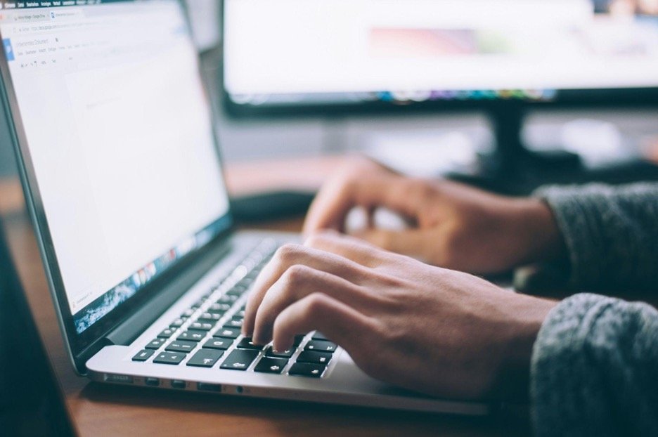 person typing on macbook pro