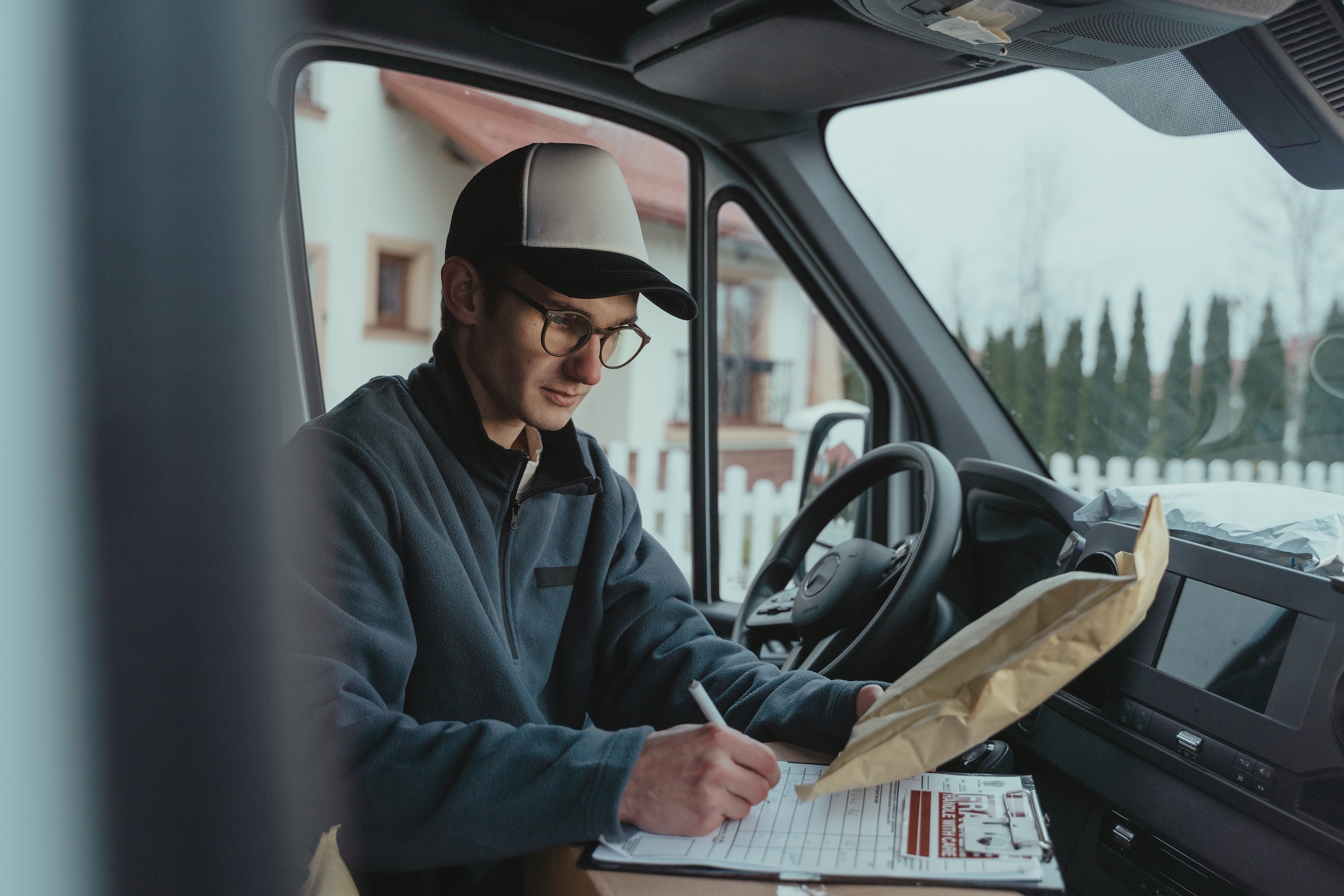 man writing on box in car