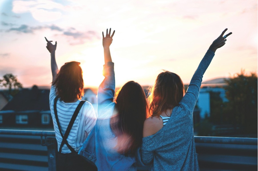 photo-of-three-women-lifting-their-hands